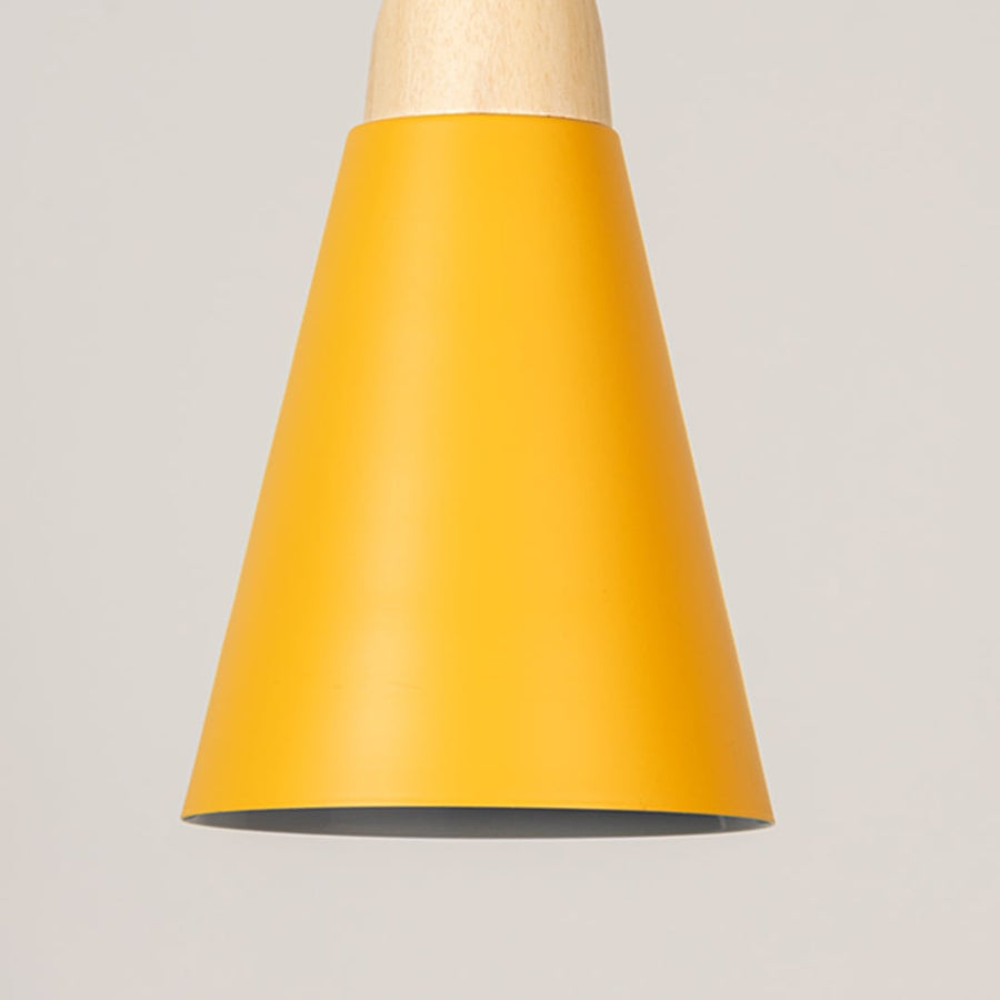 Closeup of yellow pendant light with wooden top showing elegant matte shade design for modern home decor.