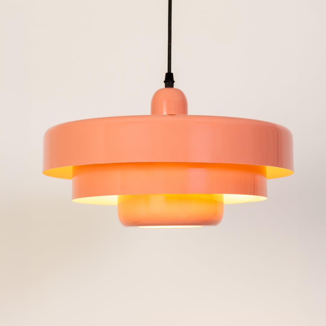 Modern peach metal pendant light glowing softly for kitchen and dining decor on a clean white background.