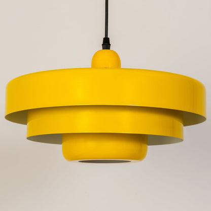 Closeup of yellow metal pendant light showing layered modern design for stylish kitchen dining and living room decor.