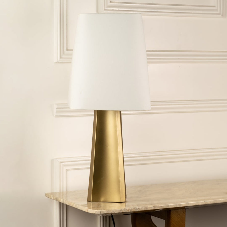 Brass metal table lamp with tapered base and white fabric shade for timeless bedside and console table styling.