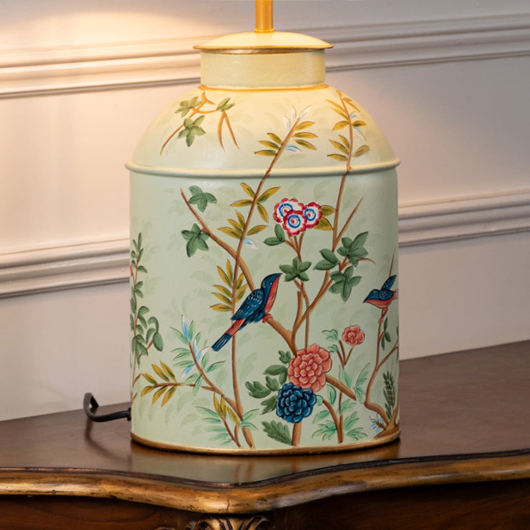 Table lamp closeup showing cream ceramic base with hand painted floral and bird design and matching fabric shade.