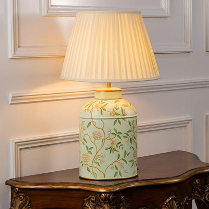 Tropical Garden white table lamp on white background glowing gently with botanical pattern and clean modern interior look.