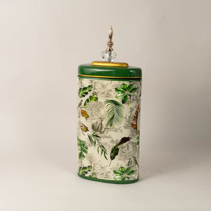 Side angle of tropical decorative jar showing sleek curved form and detailed foliage patterns with gold rim.