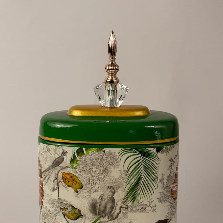 Closeup of green tropical decorative jar showing fine hand-painted tropical leaves and glossy enamel finish.