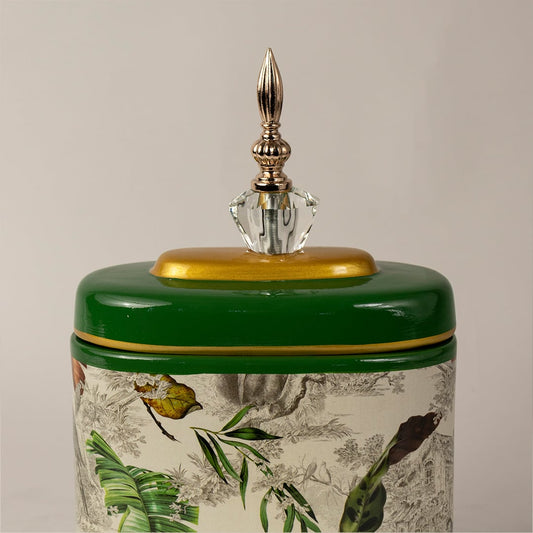 Closeup of green tropical jar showing fine leaf patterns  gold accents  and crystal top detailing.