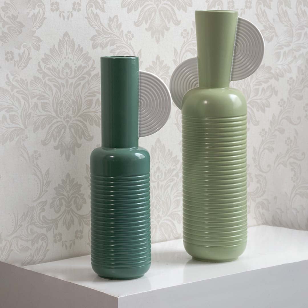 Mint green sculptural vase grouped with contemporary decor pieces creating a stylish coordinated modern display.