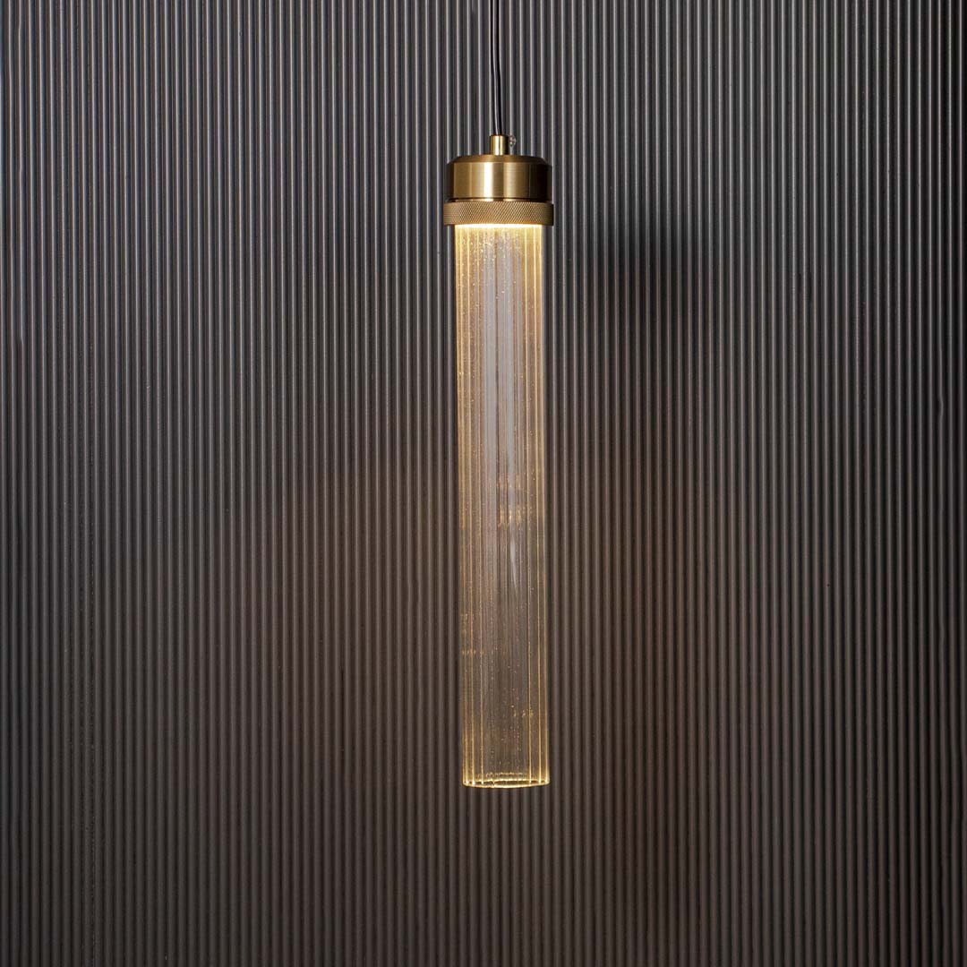 Tubular glass pendant lamp glowing with golden holder ribbed glass design elegant ceiling light for luxury modern home interiors.