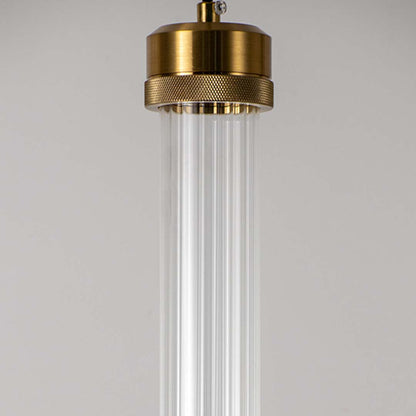 Closeup of clear glass tube pendant light with polished brass fittings highlighting elegant craftsmanship.