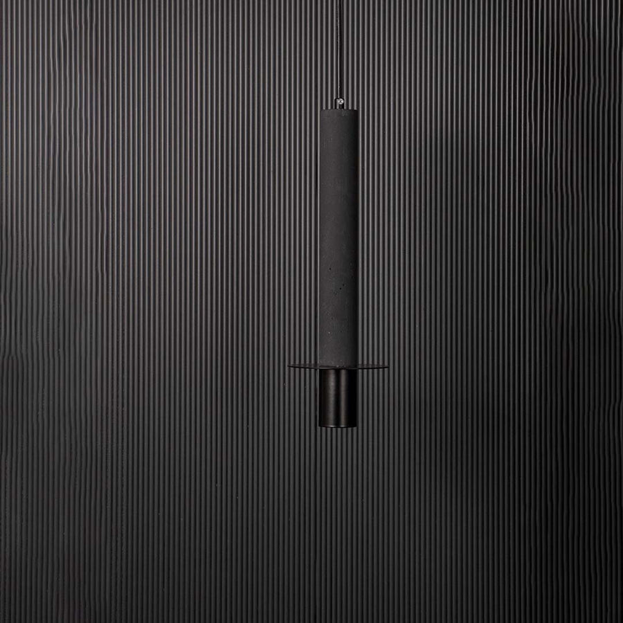 Closeup of slim black cylindrical pendant ceiling light showing fine details and modern minimalist hanging design style.