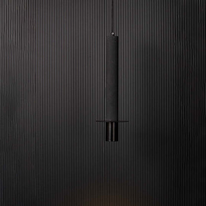 Black cylindrical pendant ceiling light glowing softly against black background creating a modern and elegant interior style.