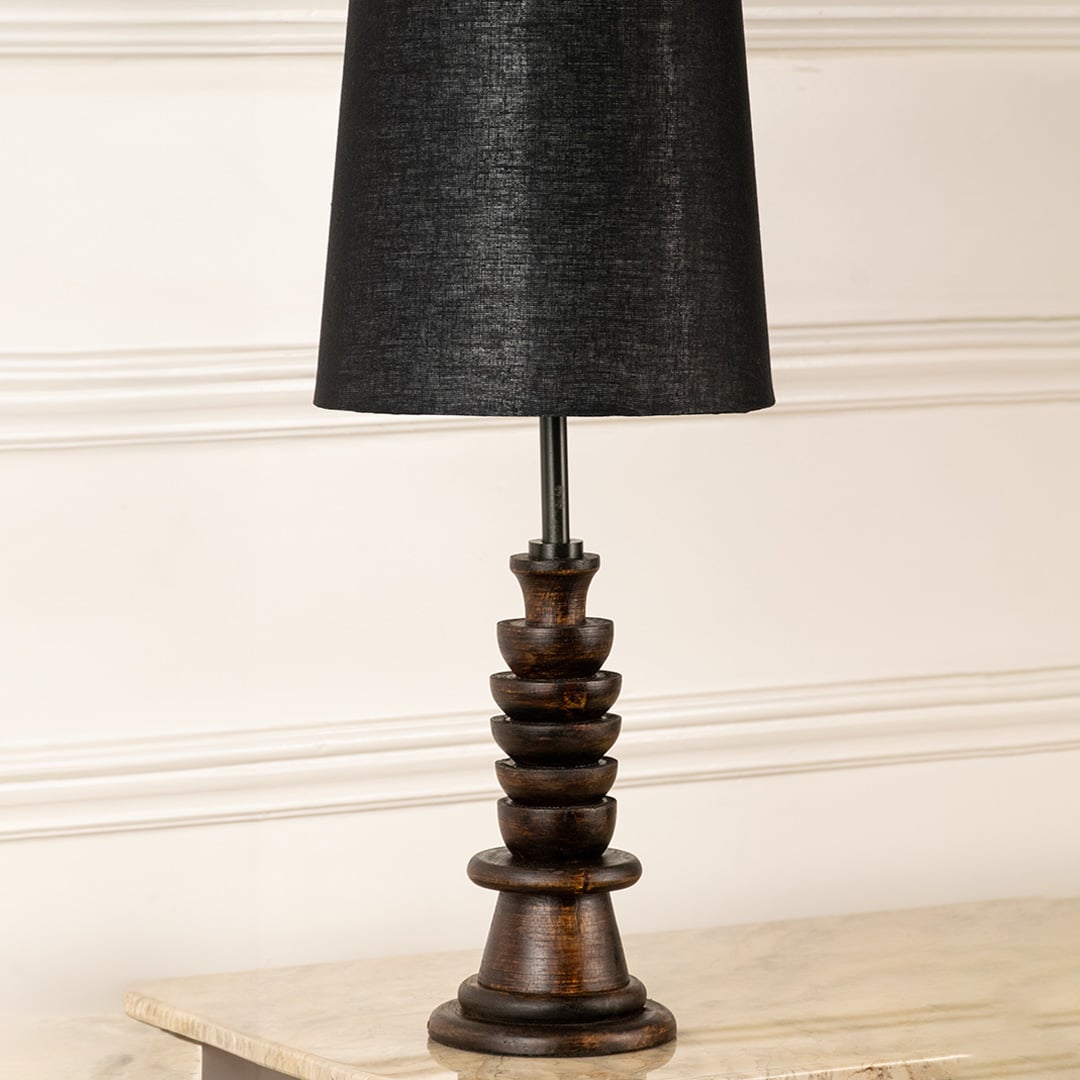 Turned wood lamp base with rich dark finish and bronze accents showcasing classic craftsmanship and decorative appeal.