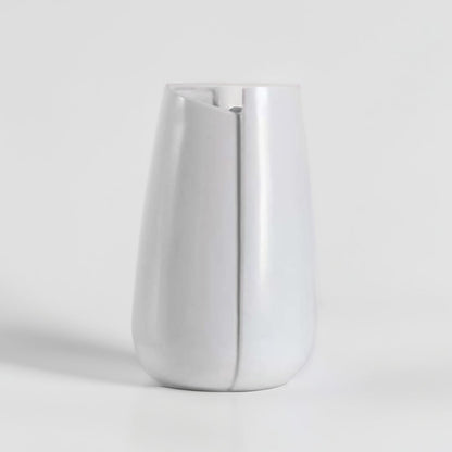 Modern white ceramic vase showcased on a white pedestal with a bright neutral background  emphasizing its simple and refined silhouette.