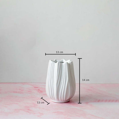 White-ceramic-vase with measurement dimensions 14 cm height and 13 cm width shown on pink marble surface for scale reference.