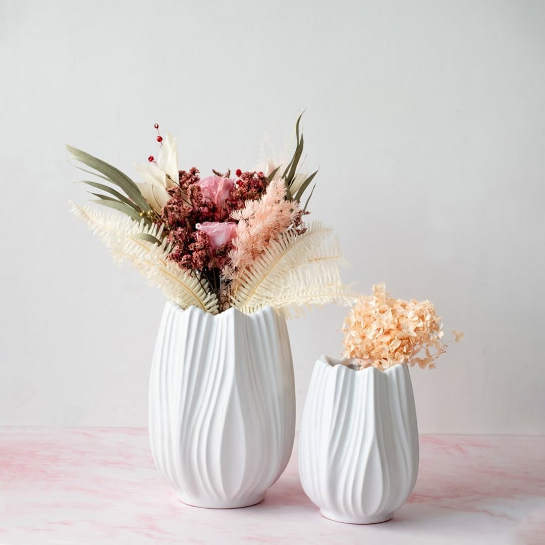 Stylish white ceramic vase with artificial flowers arranged in a modern home setting perfect for living room or dining table decor.