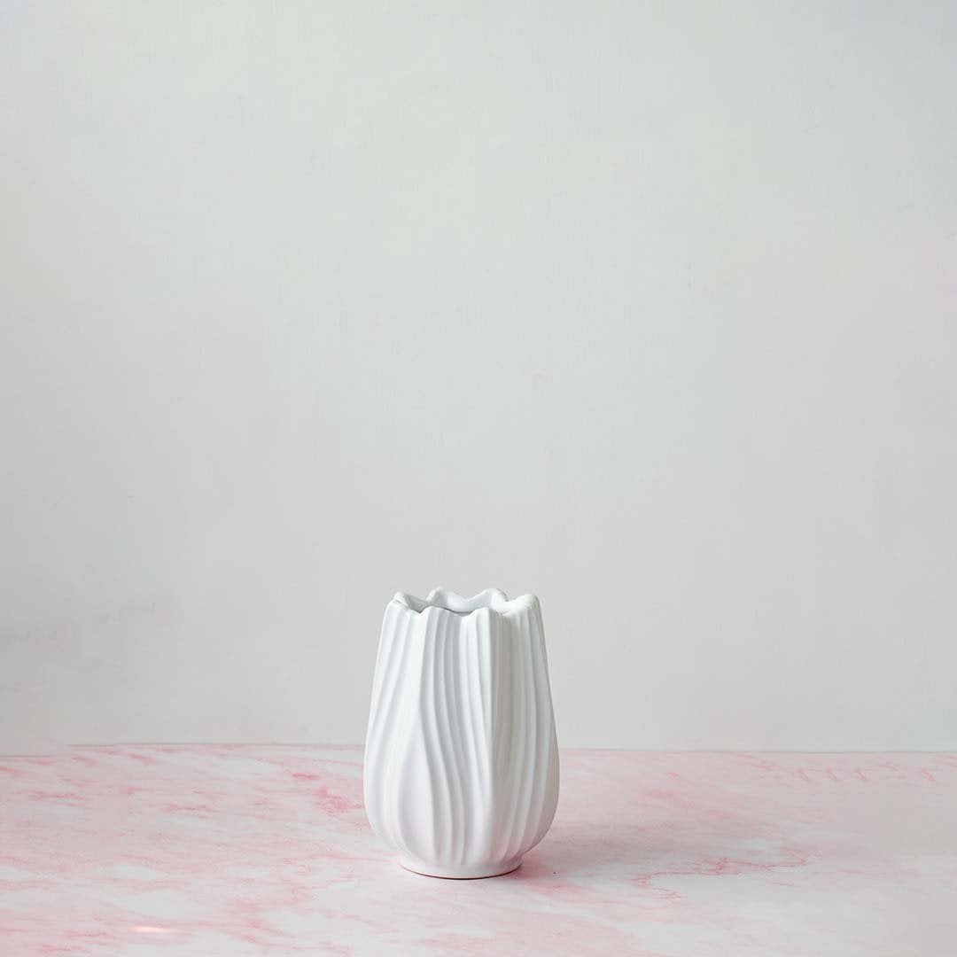 Classic white-ceramic-vase photographed on off-white background displaying smooth texture and modern minimalist style.
