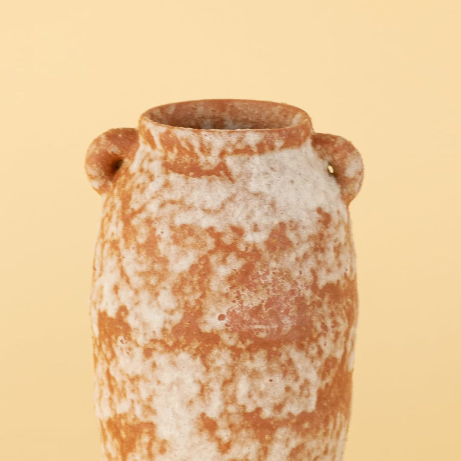 Rustic terracotta ceramic vase with narrow top and handmade orange white texture showing natural artisan surface detail.