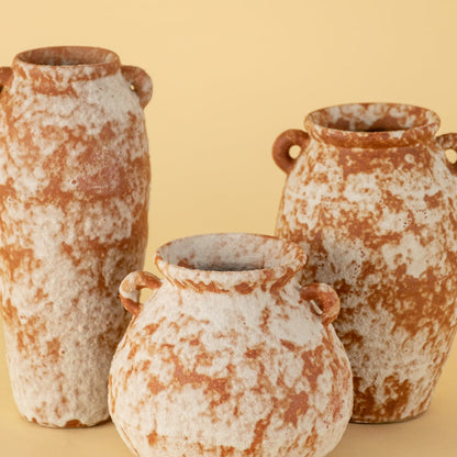 Set of rustic terracotta ceramic vases with unique shapes and dual handles in earthy finish for tabletop decoration.