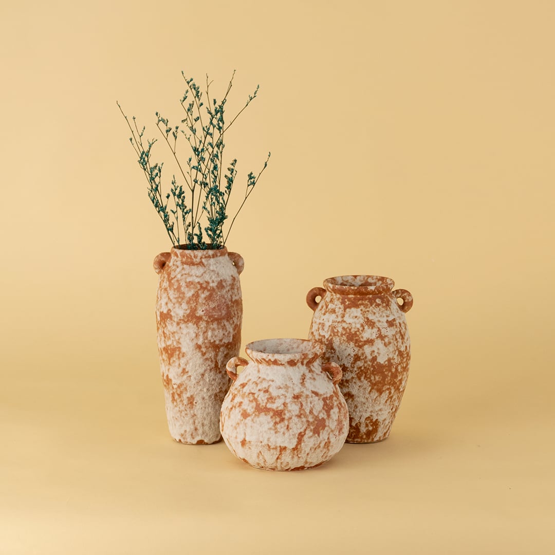 Collection of terracotta ceramic vases in rustic textured brown white finish styled together for home decor accent.