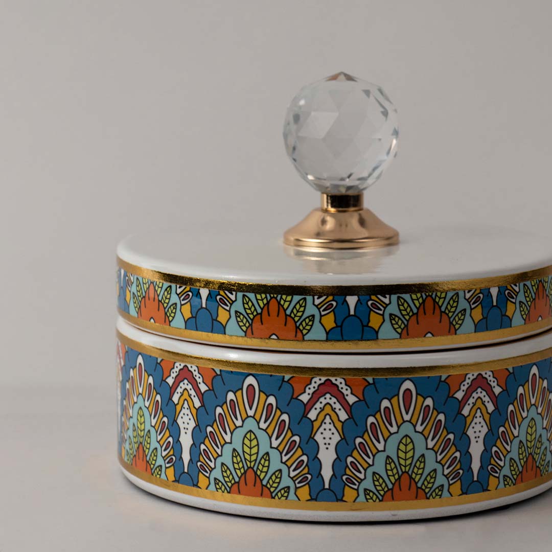 Closeup of colorful ceramic decor jar showing detailed geometric pattern and shiny crystal knob lid with gold base.