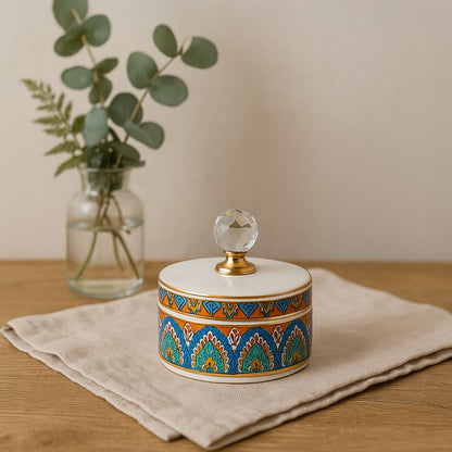 Small colorful ceramic jar with crystal knob lid styled on table adding artistic elegance to modern home decor.