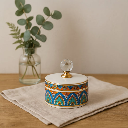 Small colorful ceramic jar with crystal knob lid styled on table adding artistic elegance to modern home decor.