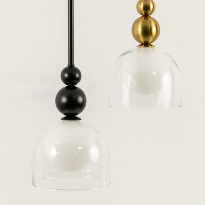 A pendant pair with black fittings and white globes enclosed in clear glass shades ideal for modern LED lighting and minimal interior décor styling.