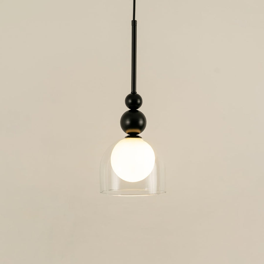 Black metal wall light with frosted glass globe illuminated to highlight sleek contemporary decorative lighting style.