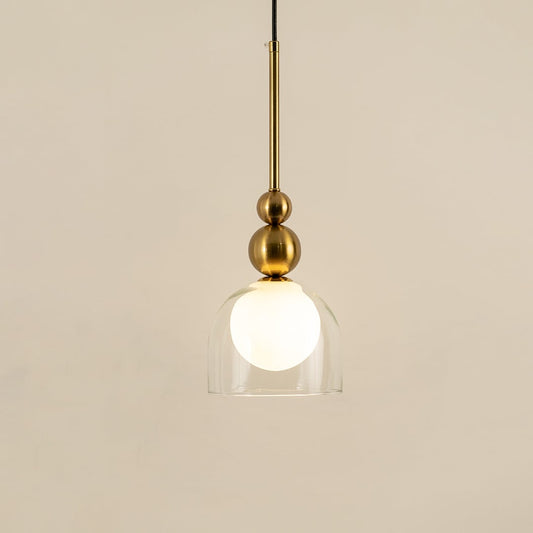 Gold metal pendant light with frosted glass globe illuminated to display luxury modern decorative ceiling lighting.