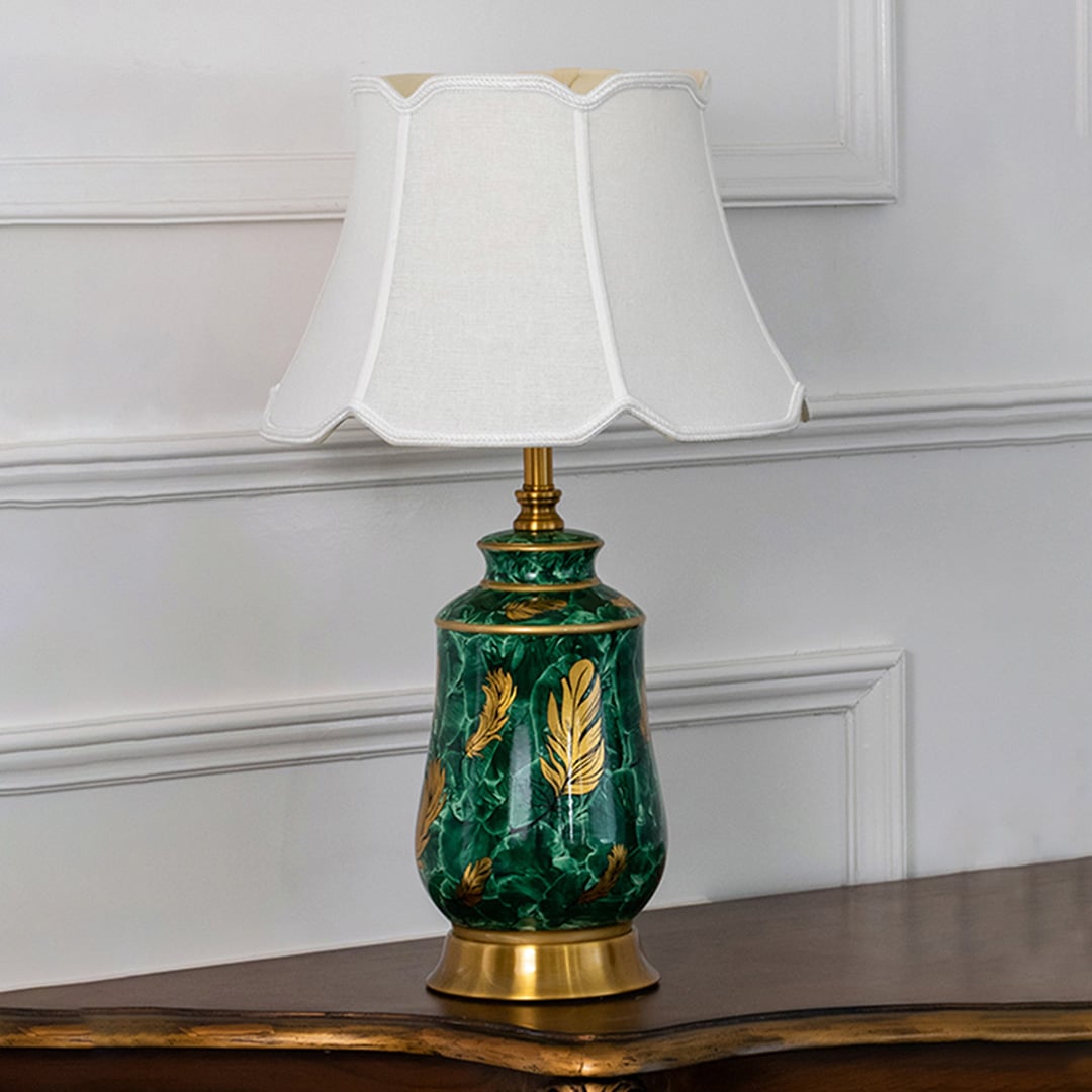 Graceful green ceramic lamp with gold details and a white shade maintaining timeless charm even when unlit ideal for elegant interiors.