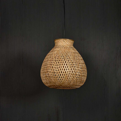 Woven rattan pendant light with bulbous handcrafted shade shown off on black background for rustic home decor.