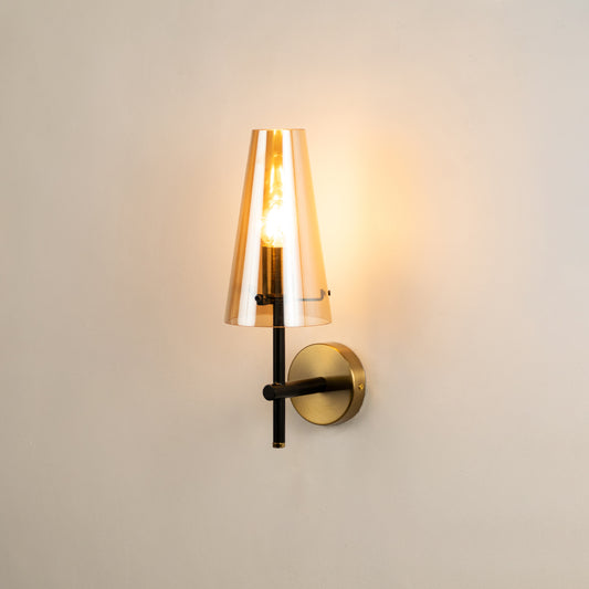 Modern brass wall light with cone glass shade creating warm elegant interior lighting ambiance.
