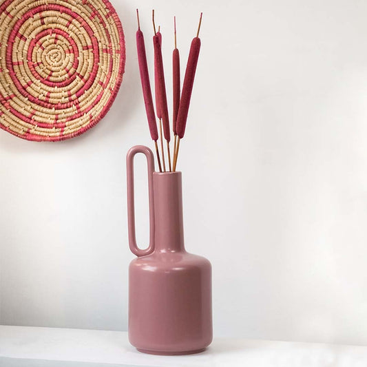 Red cattail stems displayed in a tall vase adding rustic charm to classic Indian home interior styling.