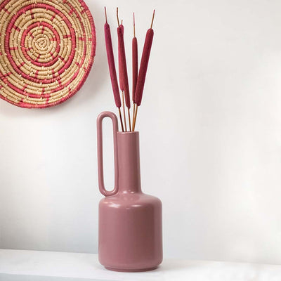 Red cattail stems displayed in a tall vase adding rustic charm to classic Indian home interior styling.