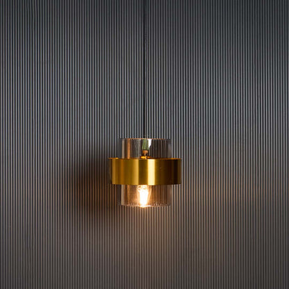 Gold glass pendant light glowing warmly against black background creating elegant contrast for premium home interiors.