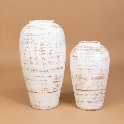 White rustic tall vase paired with complementing decor elements offering a cohesive styled arrangement for modern interior decor spaces.