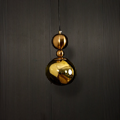 Golden pendant light displayed on dark background with light off showcasing elegant and luxurious metal finish.
