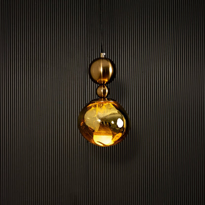 Elegant gold pendant light illuminated beautifully on dark background highlighting rich metallic golden sheen.