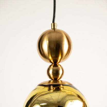 Close view of gold pendant light showing smooth reflective surface and refined metallic craftsmanship detail.