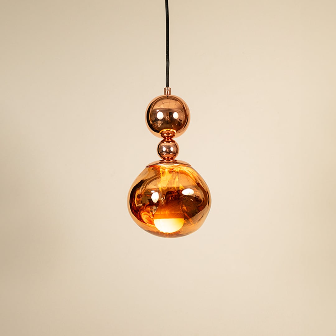 Copper metallic pendant light glowing on white background showcasing elegant design for modern home lighting.