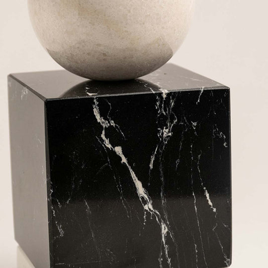 Black marble decorative sculpture with beige stone sphere for luxury shelf styling and contemporary home decor.