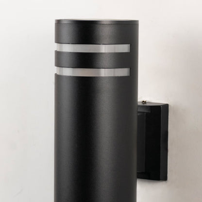 Closeup of tall black cylindrical wall light with smooth matte surface and refined dual silver ring detailing.