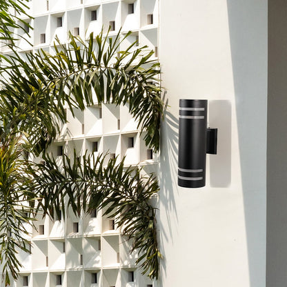 Modern outdoor black cylindrical wall light adding contemporary style and warm lighting to exterior walls.