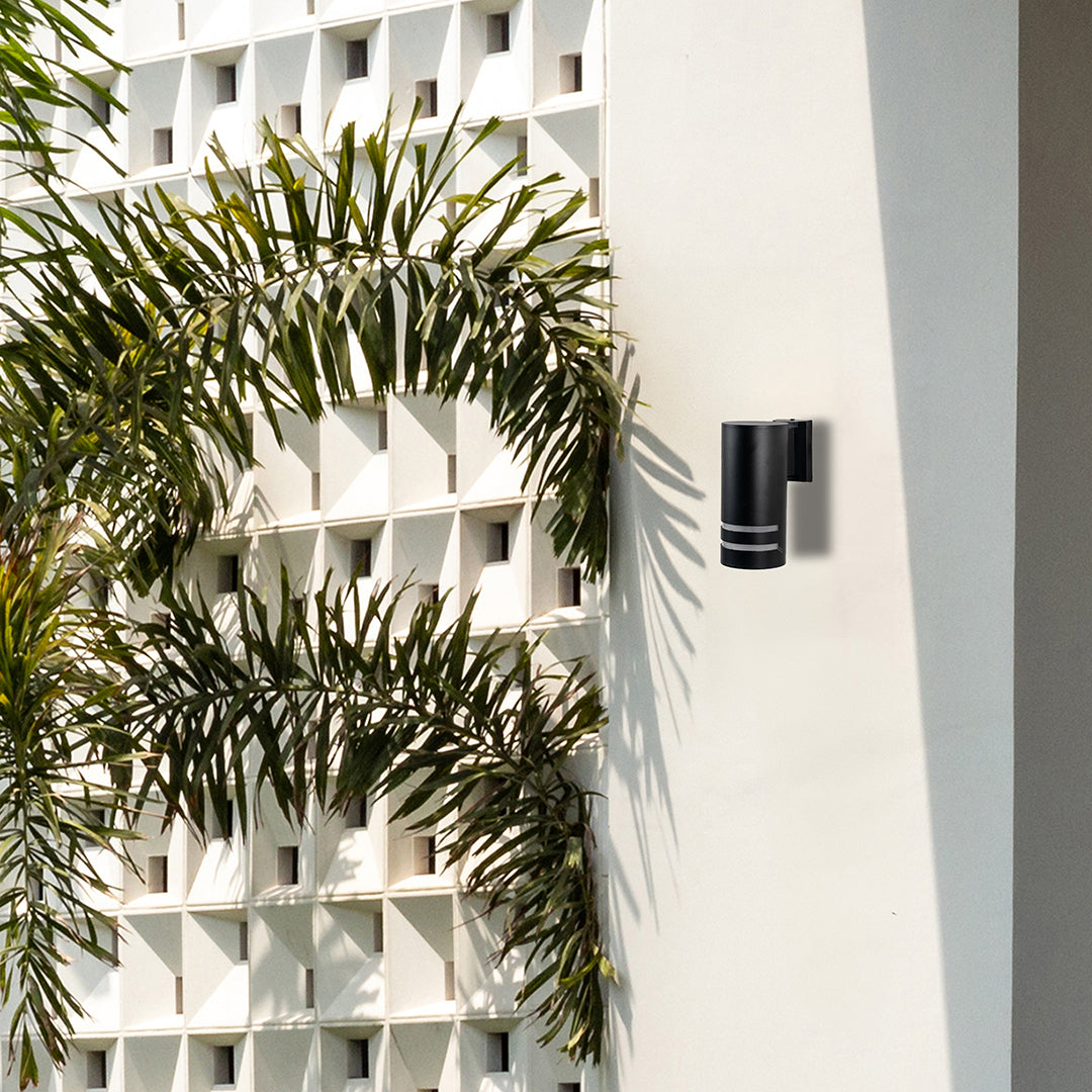 Contemporary outdoor black cylindrical wall light casting balanced illumination with stylish dual-ring accents.