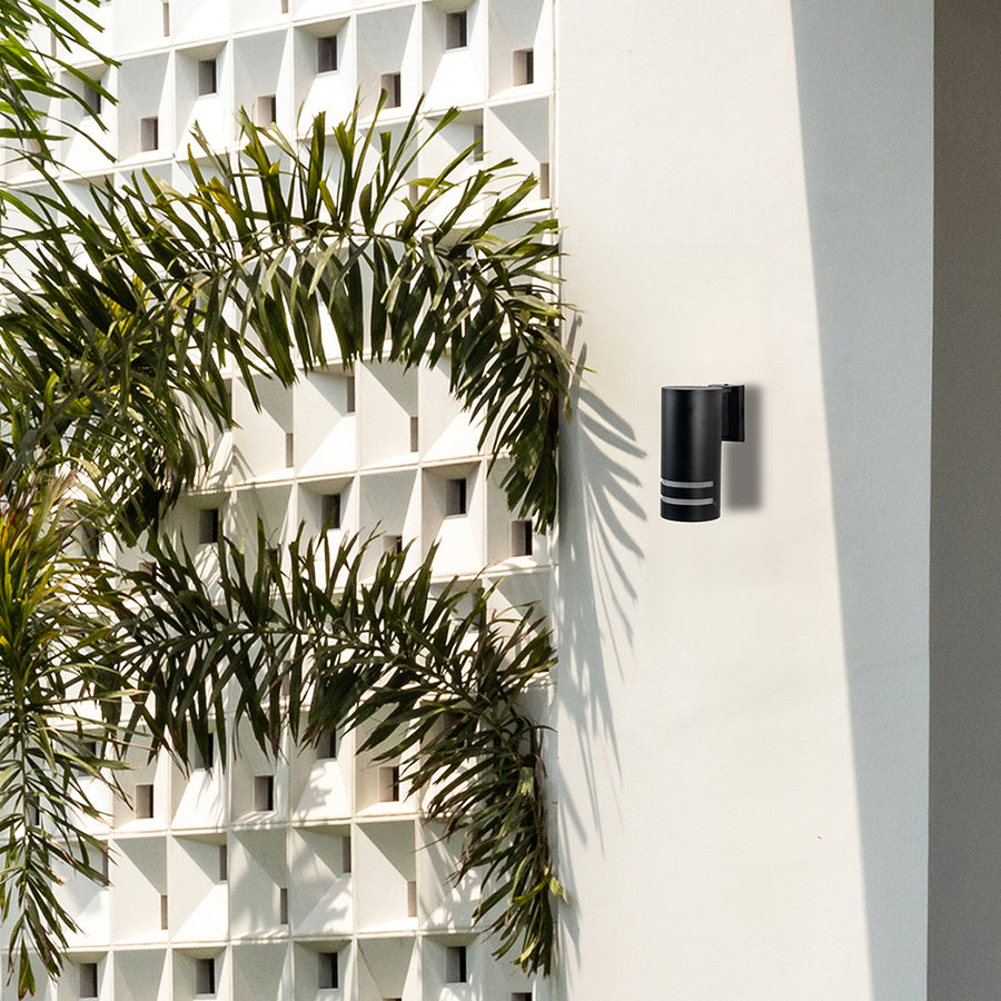 Contemporary outdoor black cylindrical wall light casting balanced illumination with stylish dual-ring accents.