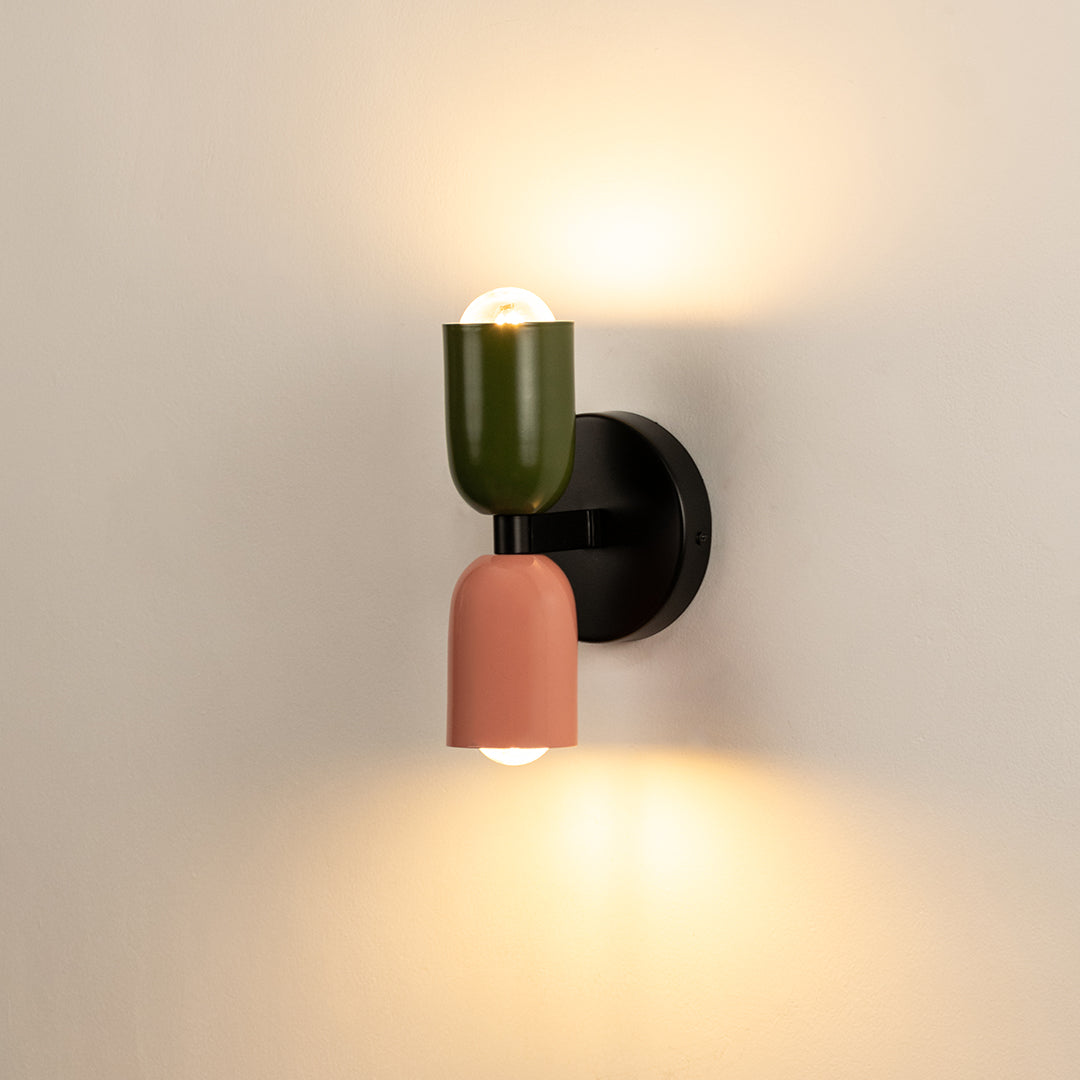 Modern green and peach wall light with warm glow for artistic contemporary interior decor.