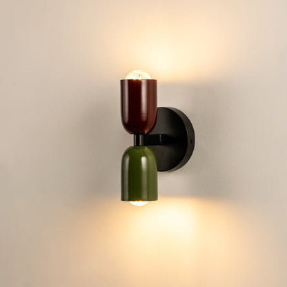 Modern dual tone wall light in red and green with black base glowing on white background perfect for home interiors.