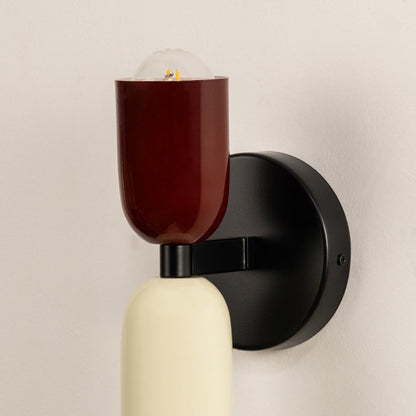 Closeup of red and cream wall lamp showing smooth metal finish and refined craftsmanship for elegant interiors.
