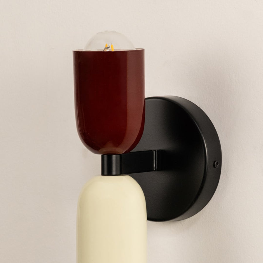 Closeup of red and cream wall lamp showing smooth metal finish and refined craftsmanship for elegant interiors.