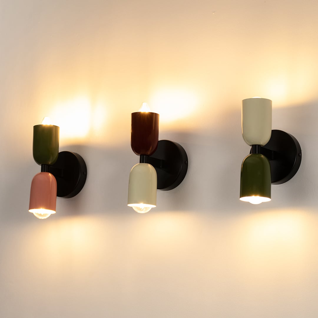 Collection of dual tone red and cream wall sconces arranged together showcasing stylish modern home lighting.