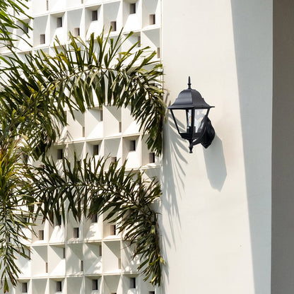 Black metal outdoor wall light lifestyle image on modern exterior wall for stylish outdoor lighting decor.